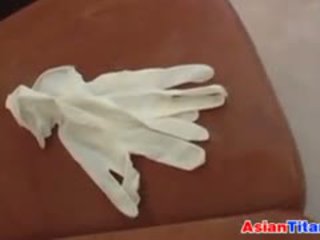 An азіатська gives a мастурбація з латекс рукавички